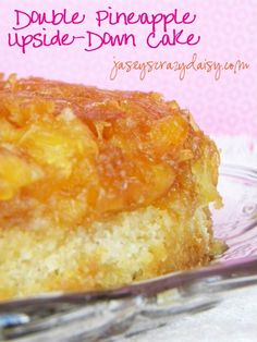 a piece of pineapple upside down cake on a glass plate with a pink background