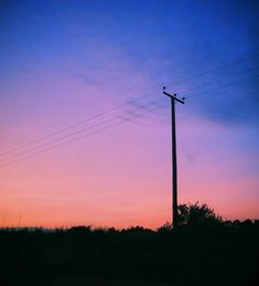 the sky is pink and blue with power lines above it at sunset or dawn,