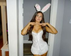 a woman in a white dress and bunny ears