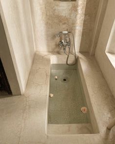 a bathroom with a shower, sink and toilet paper roll on the floor next to it