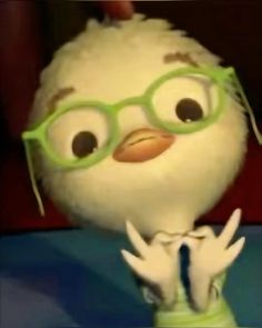 a stuffed bird with glasses on it's head and hands in front of him