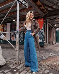 Groovy 70s style fashion featuring flared pants, platform shoes, and a statement necklace. Embrace the bohemian vibes with this retro look. #Style #Woman 70s style womens shirt, 70's style womens tops, 70s style women's hair Western Outfits Men, Fall Fashion Skirts, Leopard Coat, Leopard Print Coat, Look Retro