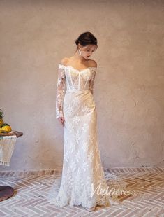 a woman in a white dress standing next to a wall with fruit on the floor