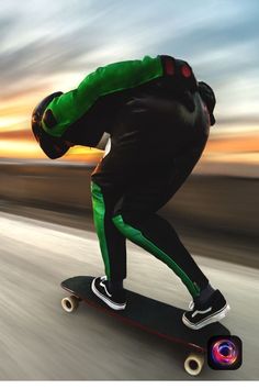 a man riding a skateboard down a street next to the ocean at sunset or dawn