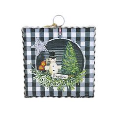 a christmas ornament with a dog and tree in the center on a black and white checkered background