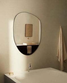 a bathroom with a sink, mirror and towels hanging on the wall next to it