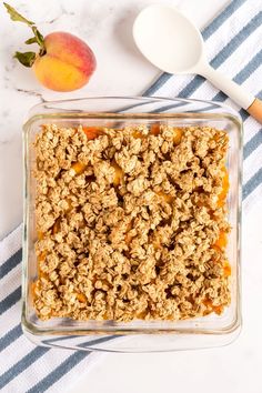 a glass dish filled with granola next to an orange