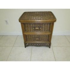 a wicker nightstand with two drawers on the bottom and one drawer open, sitting on a tile floor