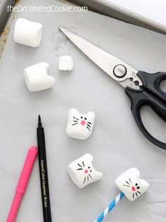 some marshmallows are sitting on a tray next to scissors and other items