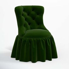 a green velvet chair with ruffles on the back and seat, in front of a white background