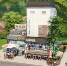 a small model of a restaurant with tables and chairs in the foreground, surrounded by trees