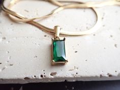 Get your shimmer on! An amazing minimalist gold herringbone chain necklace with a beautiful and dainty emerald green crystal pendant. The pendant is emerald colored crystal cut into a rectangular baguette shape and hand set in a high quality 18k gold plated setting. Length: 16 inchesPendants: 6mm wide by 15mm tall✦Ready for gifting in a cute boho gift box. ✦Ships same day or next, check shop announcement for twice yearly shipping delays (A girl needs a vacation every now and then even when she l Emerald Necklace Gold, Tribe Jewelry, Silver Bracelet Designs, Gold Herringbone Chain, Emerald Green Crystal, Herringbone Chain, Emerald City, Emerald Necklace, Green Crystal