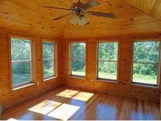 an empty room with wood paneling and windows