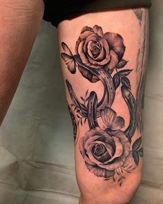 a woman's thigh with roses and butterflies on it, in black and white