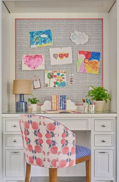 a desk with a chair and pictures on the wall