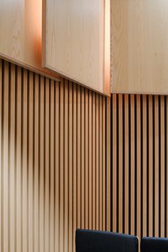 two chairs are in front of a wall with wooden paneling on the back and sides