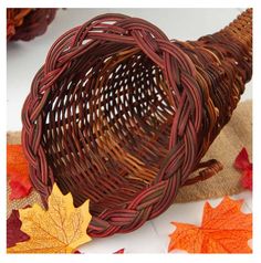 a wicker basket with autumn leaves around it