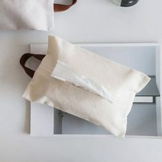 a white pillow sitting on top of a table next to a camera and other items