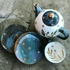 three ceramic dishes and a teapot are on the ground with stars painted on them