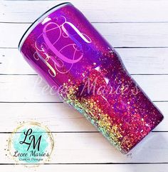 a purple and pink glitter tumbler with the letter e on it's side