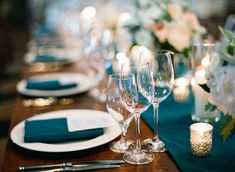 the table is set with wine glasses and place settings