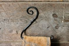 an old towel hanging from a hook on a wooden wall