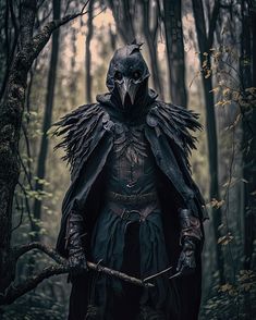 a man dressed in black standing in the woods with a crow on his head and holding a stick