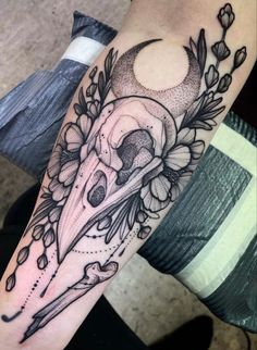 a person with a tattoo on their arm holding a knife and flower bouquets in front of them