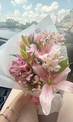 a bouquet of pink flowers sitting in the passenger seat of a car