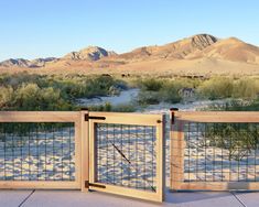 an open gate in the desert with mountains in the background