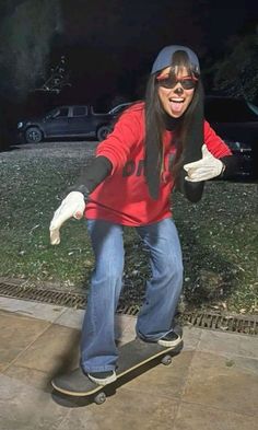 a woman riding a skateboard on top of a sidewalk