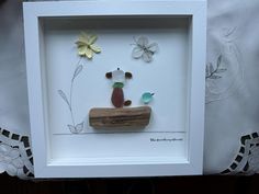 a white frame with some paper flowers on it