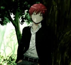 a man with red hair standing next to a tree