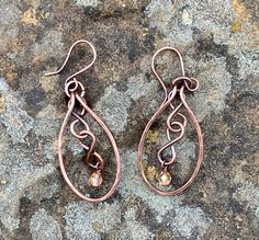 Hammered Copper with copper figure eights and flame colored crystal dangles. Come on handmade copper ear wires.Approximately 2" long from the top of the ear wire and 13/16" wideThese Earrings have been antiqued, polished and sealed.Sealed with Protectaclear ProtectaClear is a clear, protective coating that is tough eno Hammered Copper Jewelry, Colored Wire Jewelry, Bronze Teardrop Copper Earrings, Bronze Copper Teardrop Earrings, Hand Forged Copper Wire Drop Earrings, Hand Forged Bronze Earrings With Copper Wire, Bronze Wire Wrapped Teardrop Earrings, Copper Teardrop Dangle Earrings, Bronze Wire Wrapped Copper Earrings