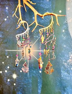 This enchanting fairy forest ear cuff is sure to make a statement and bring out your inner magic! Gold or silver ear cuff wrap is adorned with an electroplated rainbow tree branch, iridescent glass beads, fairy, moon, star, leaf, and mushroom charms, and a hand wire wrapped rainbow quartz crystal. This ear cuff is perfect for adorning non-pierced ears and pierced ears! Please note that each quartz crystal is unique so the shape, size, and coloration may vary slightly from what is shown in the Bohemian Dangle Body Jewelry For Festivals, Fantasy Dangle Earrings For Festival, Fantasy Festival Earrings, Fantasy Style Single Earring For Festival, Handmade Fantasy Earrings For Festivals, Bohemian Style Pierced Ear Cuff For Party, Silver Bohemian Cartilage Earrings For Party, Bohemian Single Earring Crystal Earrings For Party, Handmade Dangle Ear Cuff For Festivals