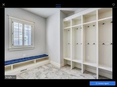 an empty room with white shelves and blue cushion