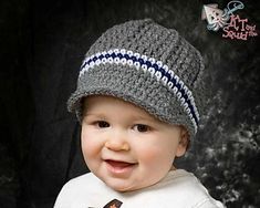 a smiling baby wearing a knitted hat with stripes on it's brim