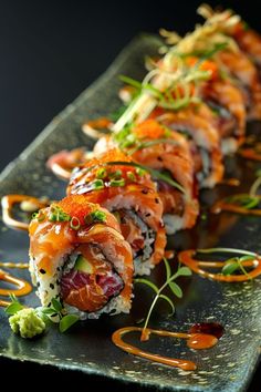 sushi rolls on a plate with sauce and garnishes are ready to be eaten