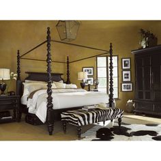 a bedroom with a zebra print rug on the floor and four poster bed in it