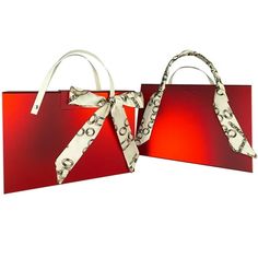 two red shopping bags with white handles and bows on the handles, one is empty