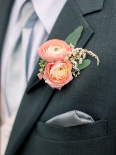 a man in a suit with flowers on his lapel and wearing a boutonniere