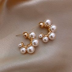 Pearls can also be a girl's best friend. Our gorgeous Pearl Hoops are a fashion accessory necessity. The hoops are gold plated with simulated pearls. Feel flashy and flirty; confident and classy. These earrings will go with every wardrobe and will Beautify your Jewelry Box. Pearl Hoops Details: Metal: Copper Alloy, Gold Plated Simulated pearls Perfect your Parure by pairing our Pearl Hoops with our White Opal Leaf Ring and our Shell Drop Chain Bohemian Wedding Earrings, Wedding Earrings Vintage, Wholesale Earrings, Unusual Earrings, Pearl Hoop Earrings, Earring Type, Pearl Earrings Dangle, Pearl Stud Earrings, Earrings Color