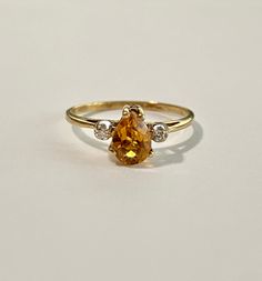 Fabulous 1980s era pear cut Citrine & diamond ring! This 10k yellow gold beauty features an approximate 3/4 carat pear cut citrine, surrounded by 2 round cut diamonds. Such a stunning and unique piece! ERA - Circa 1970s METAL / MATERIAL - 10k yellow gold, one pear cut citrine (approx. .71ct), 2 round cut diamonds (.06 ctw) MARKINGS / HISTORY - Inside of band is marked 10k CONDITION - Good condition. Stones are all secure. Some light age appropriate wear. Amazing vintage ring! SIZE / MEASUREM Pear-shaped Gold Diamond Ring, Classic Gold Diamond Pear Ring, Heirloom Yellow Gold Pear Shaped Ring, Heirloom Yellow Gold Pear-shaped Ring, Vintage Yellow Gold Pear-shaped Diamond Ring, Classic Pear-shaped Diamond Ring In 14k Gold, Vintage Pear-shaped Yellow Gold Diamond Ring, Pear-shaped Citrine Jewelry In Yellow Gold, Luxury Citrine Pear-shaped Jewelry