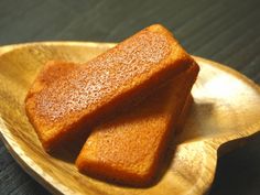 two pieces of cake sitting on top of a wooden plate