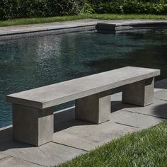 a concrete bench sitting next to a swimming pool