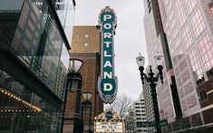 the sign for portland coffee house in front of some tall buildings and street lamps on a cloudy day