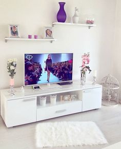 a flat screen tv sitting on top of a white entertainment center in a living room