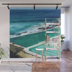 an aerial view of a swimming pool and the ocean wall mural