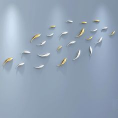 a group of white and gold leaves on a wall