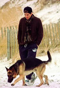 a man walking his dog in the snow